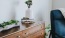 a dresser with a vase of plants on top