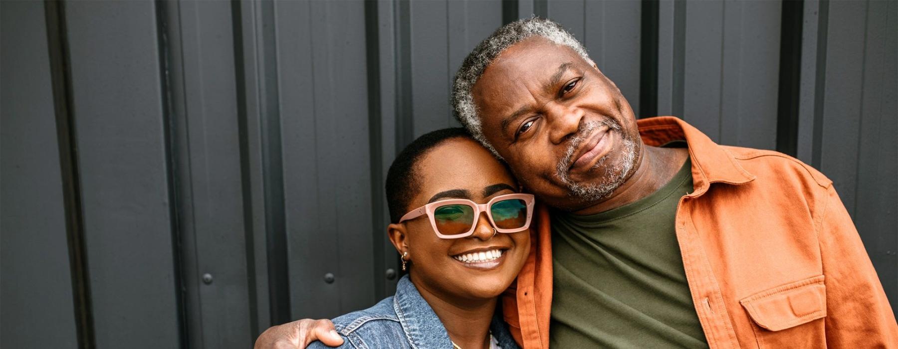 a man and woman smiling while hugging